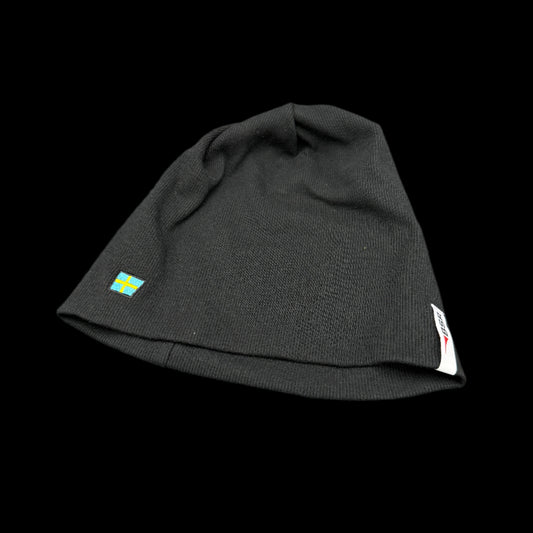 Black beanie with a small flag emblem on a gray background